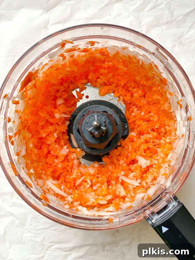 Golden Crispy Tofu Vegetable Wontons Made Two Ways 5 Post-processing shot of finely minced onions and carrots in a food processor, ready to be combined with tofu.