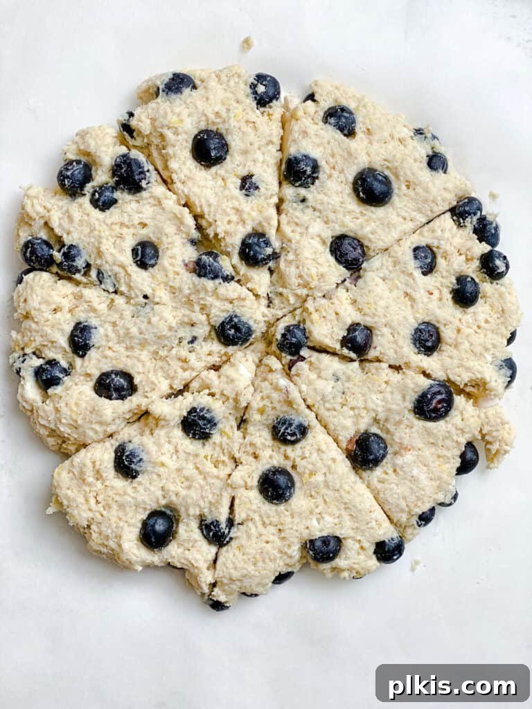 Sunshine Lemon Blueberry Plant-Based Scones 9 A process shot showing the scone dough precisely sliced into triangular pieces, ready for baking.