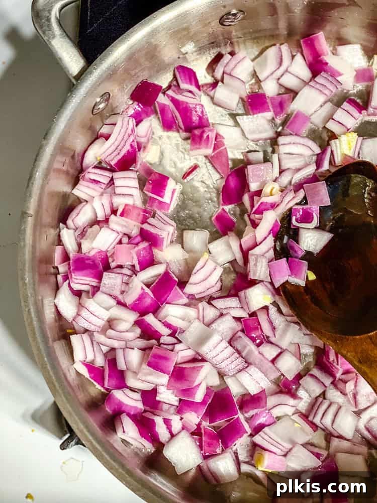 Vibrant 30-Minute Vegan Thai Red Curry 4 Step-by-step image of sautéing diced onions in a large pan for curry