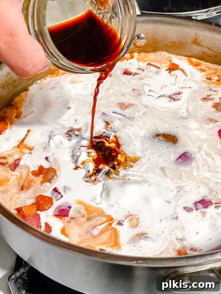 Vibrant 30-Minute Vegan Thai Red Curry 6 Step-by-step image of adding coconut milk and soy sauce to the curry base in a pan