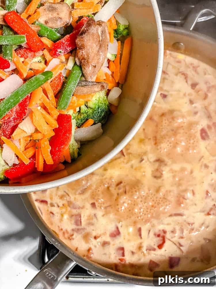 Vibrant 30-Minute Vegan Thai Red Curry 7 Step-by-step image of adding frozen stir-fry vegetables to the simmering red curry