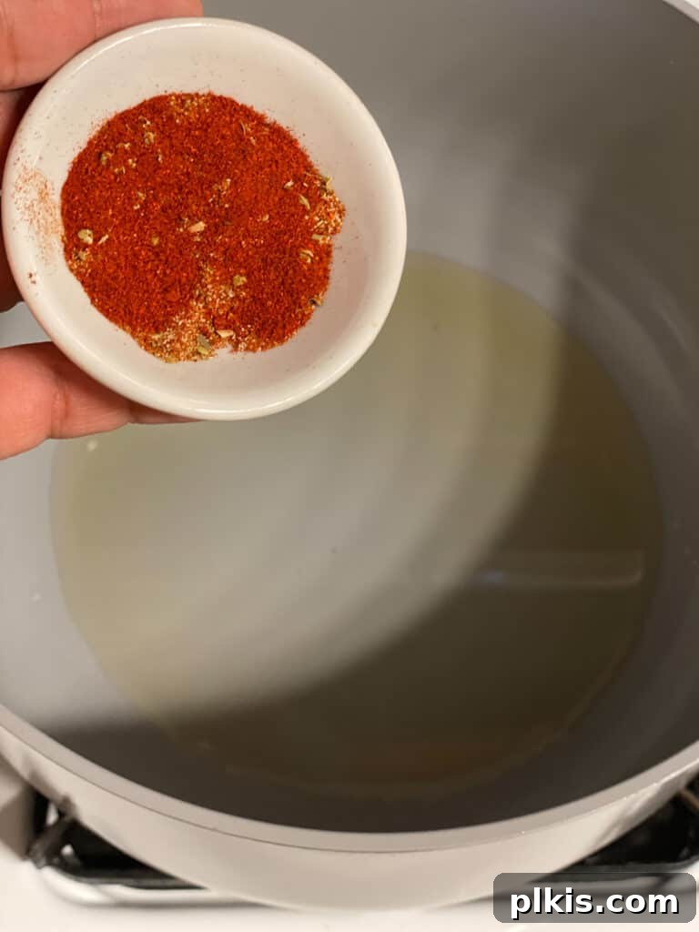 Aromatic Garlic Rice 5 Process shot showing achiote powder being added to a hot pan with oil, creating a rich base for Golden Garlic Rice.