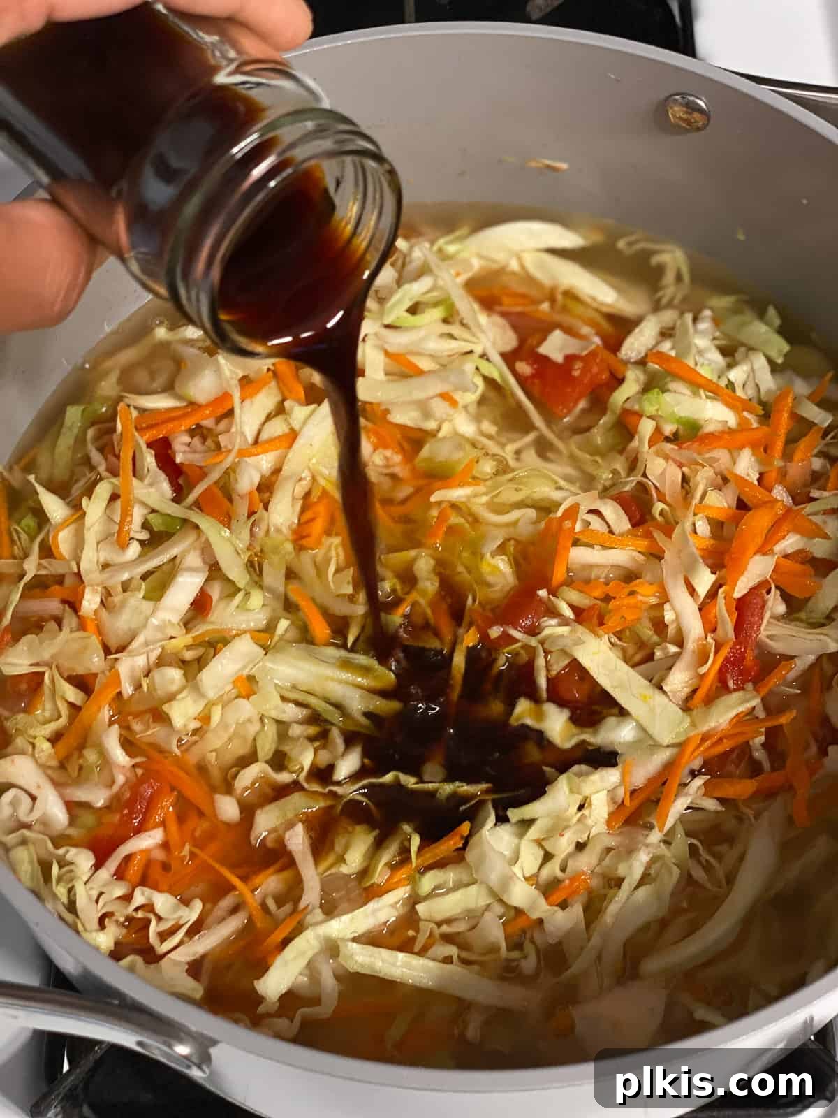 Zesty Plant-Based Hot and Sour Soup 11 process shot of adding soy sauce to pan