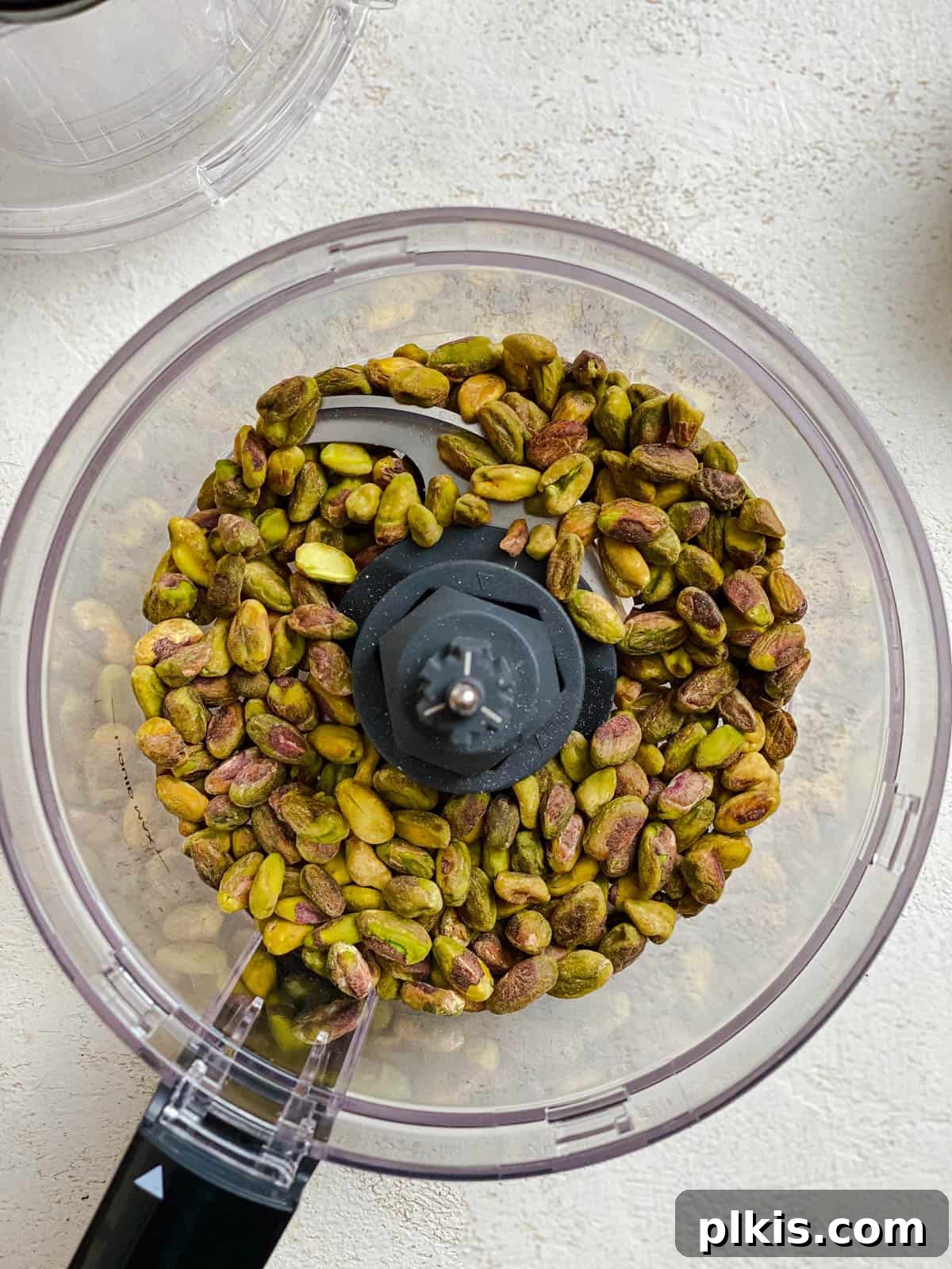 Lush Avocado Pesto Pasta 4 Pistachios being added to a food processor, ready for blending.