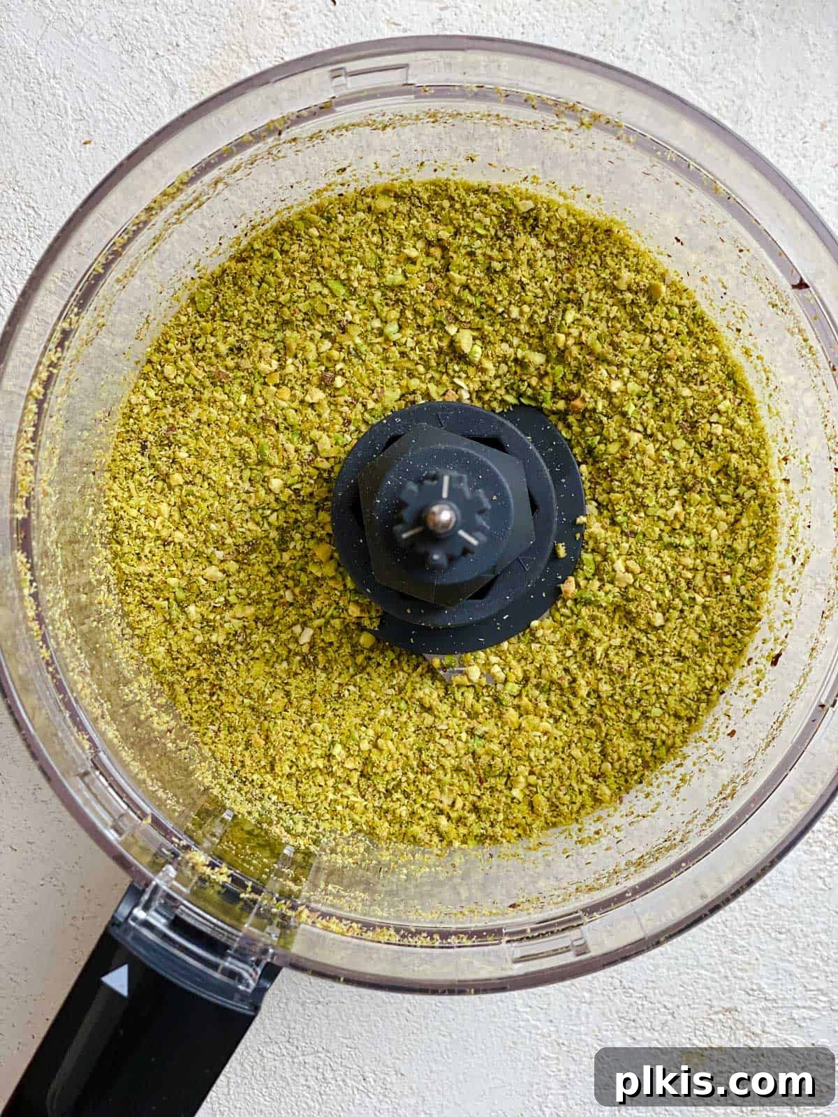 Lush Avocado Pesto Pasta 5 Avocado pesto ingredients (avocados, basil, garlic, cumin, nuts) in a food processor, ready to be blended into a creamy sauce.