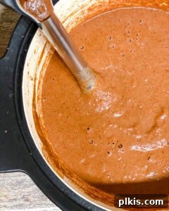 Decadent Vegan Mole 12 A pot of brown sauce with an immersion blender in it.