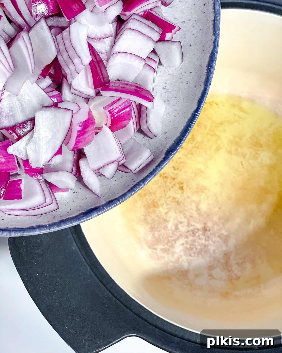Decadent Vegan Mole 4 Process shot showing chopped onion being added to a hot pot with oil.