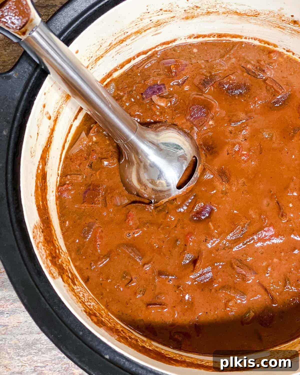 Decadent Vegan Mole 7 Process shot showing an immersion blender being used directly in the pot to smooth the mole sauce.