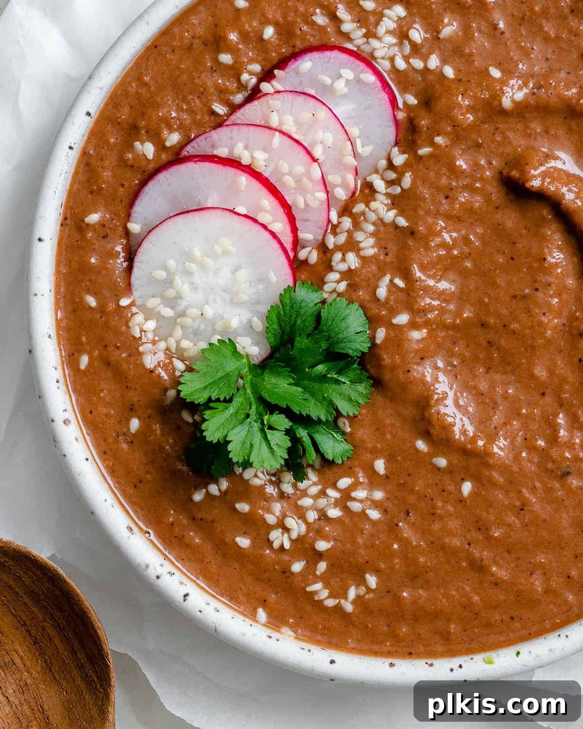 Decadent Vegan Mole 8 Close-up of a bowl of rich, smooth Quick Vegan Mole Poblano sauce, garnished with sesame seeds and cilantro.