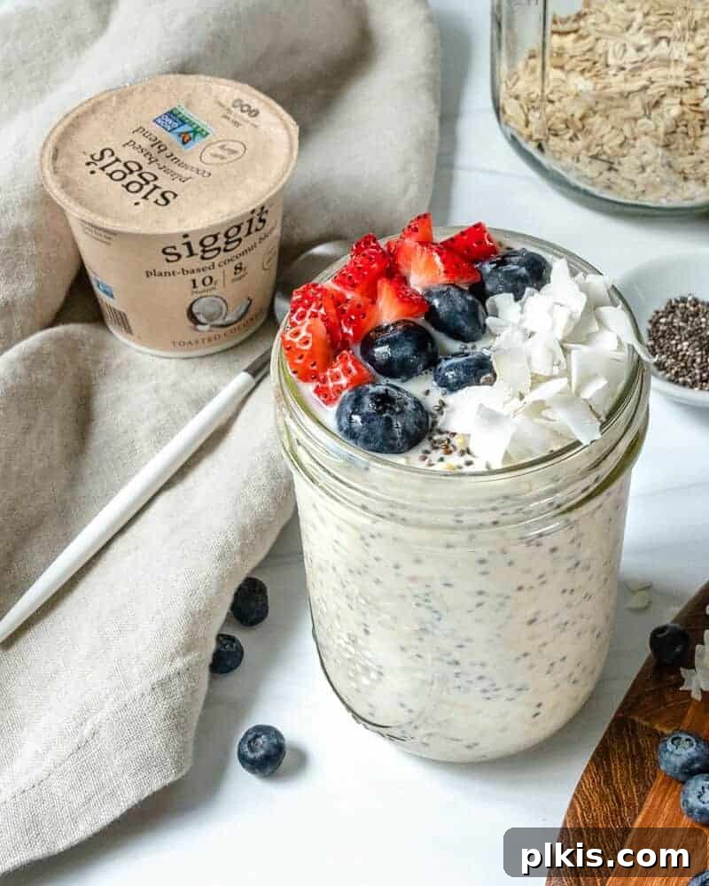 Effortless Morning Oats 2 overnight oats in glass jar with fruit on top in a white background