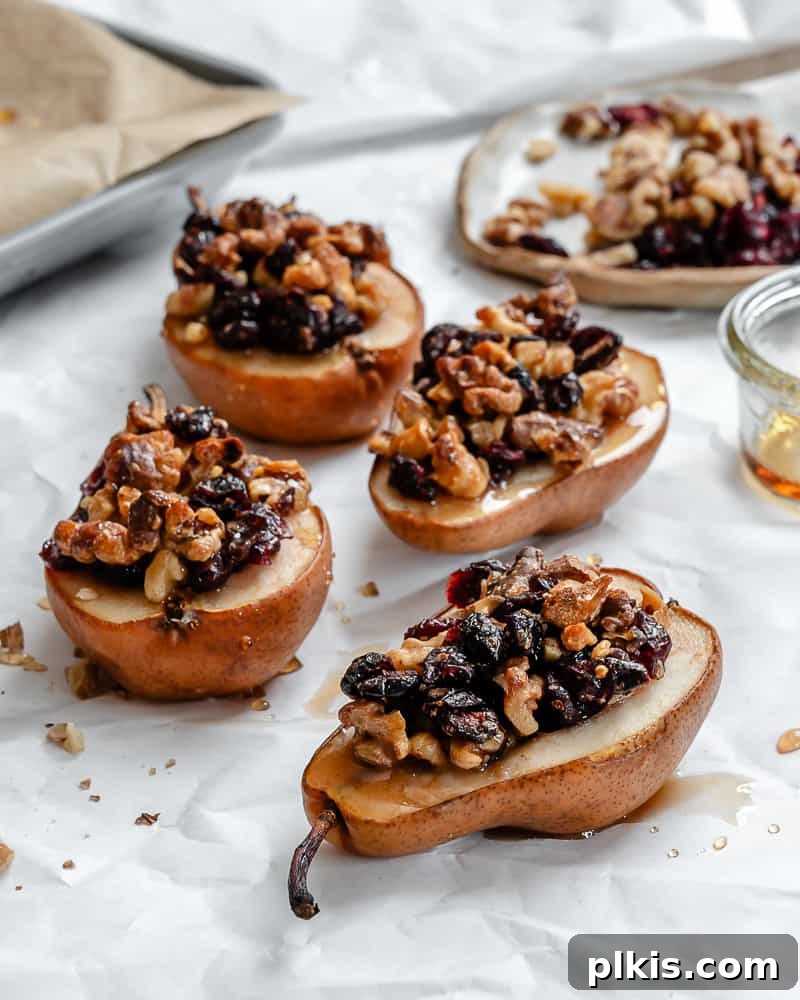 Sweet Baked Pears with Nutty Fruit Filling 2 Golden-brown baked pears, beautifully stuffed with a mix of nuts and dried fruit, resting on a clean white surface, ready to be served as a delightful dessert.