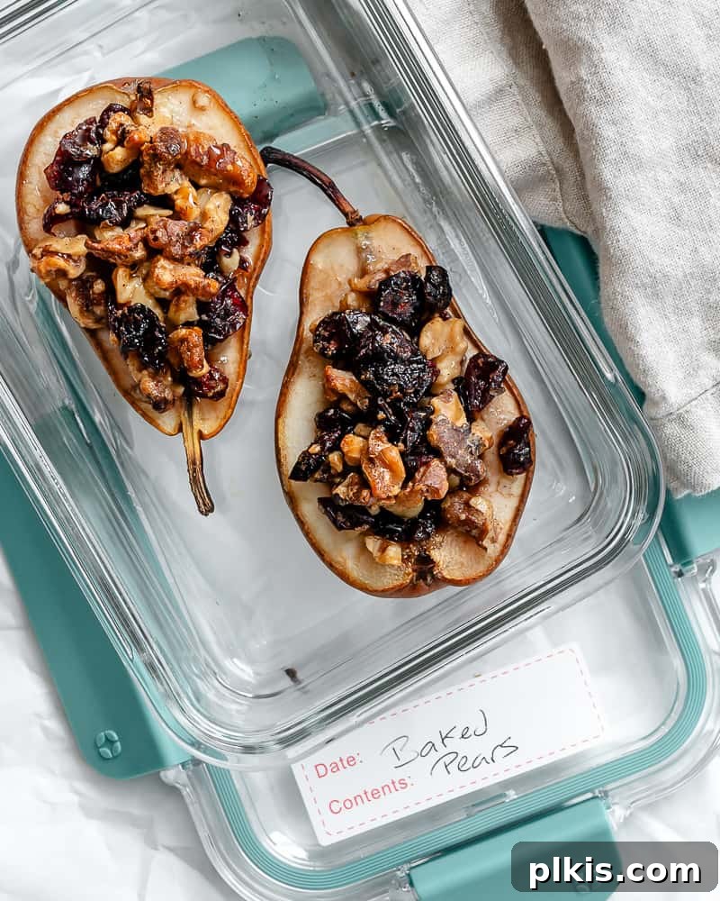 Sweet Baked Pears with Nutty Fruit Filling 11 Three baked pear halves, stuffed with nuts and fruit, neatly arranged in a clear glass storage container, highlighting their convenience for meal prep.