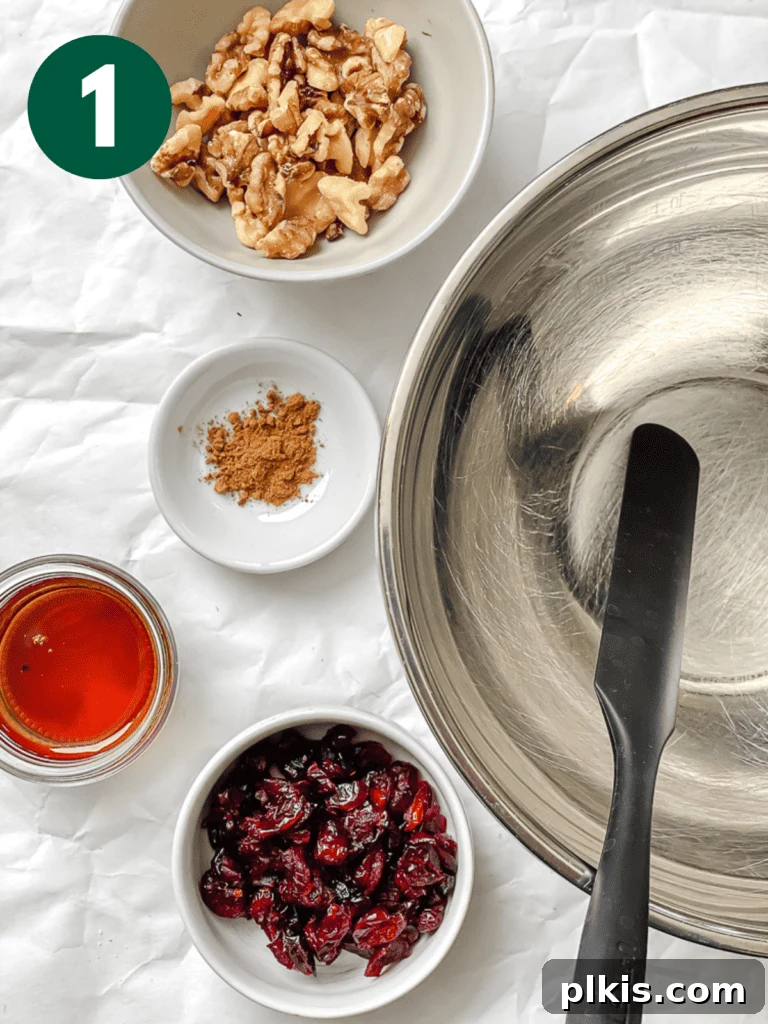Sweet Baked Pears with Nutty Fruit Filling 4 A bowl filled with a mixed nut and dried fruit stuffing, ready to be scooped into pears, alongside an empty mixing bowl.