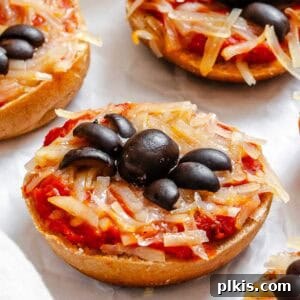 Completed Mini Spider Pizza Bagel Bites on a white surface.