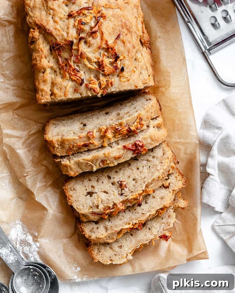 Spiced Apple Bread 2 A beautifully baked vegan apple cinnamon bread, sliced to reveal a fluffy interior studded with apple pieces and cinnamon swirls.