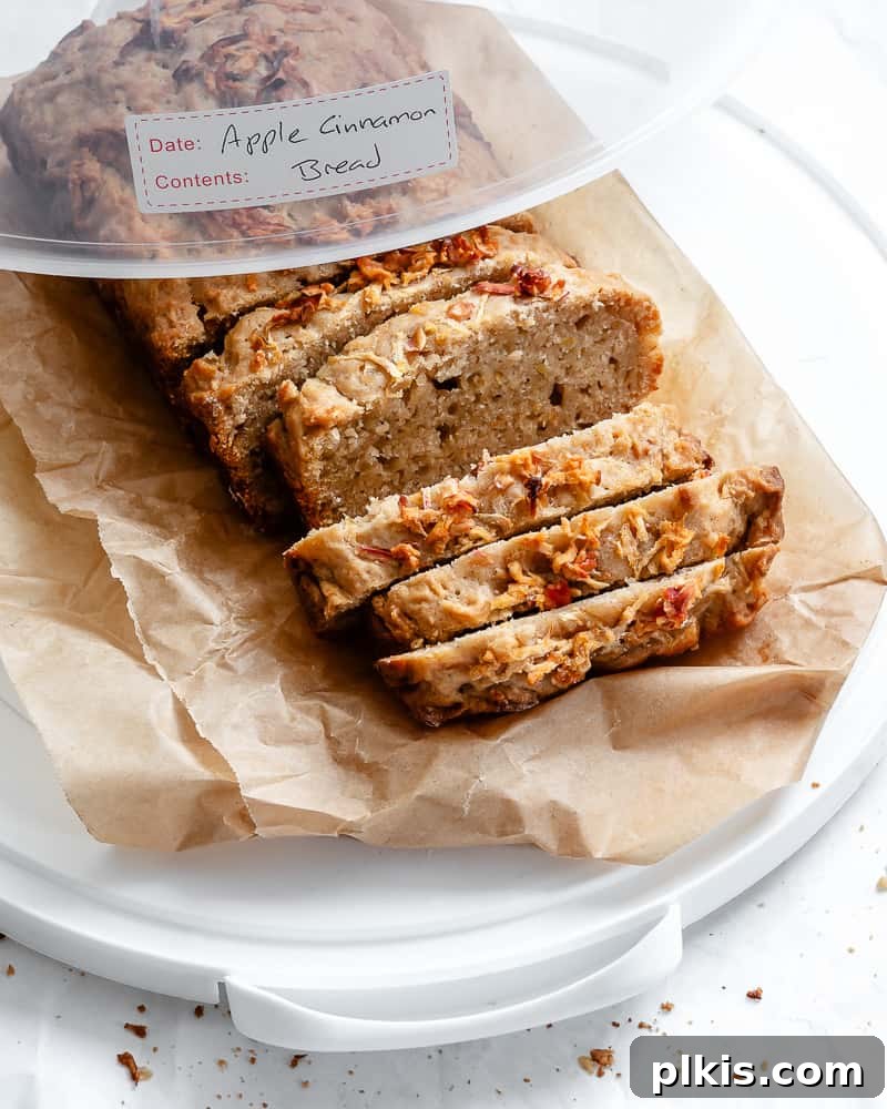 Spiced Apple Bread 13 Sliced apple cinnamon bread neatly arranged inside an airtight clear container, with a label indicating 'Apple Cinnamon Bread' for easy storage identification.