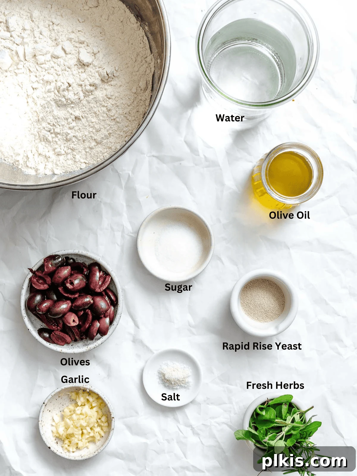 Aromatic Garlic Herb Vegan Focaccia 3 Ingredients for Vegan Focaccia (Garlic and Herb) measured out on a white surface.