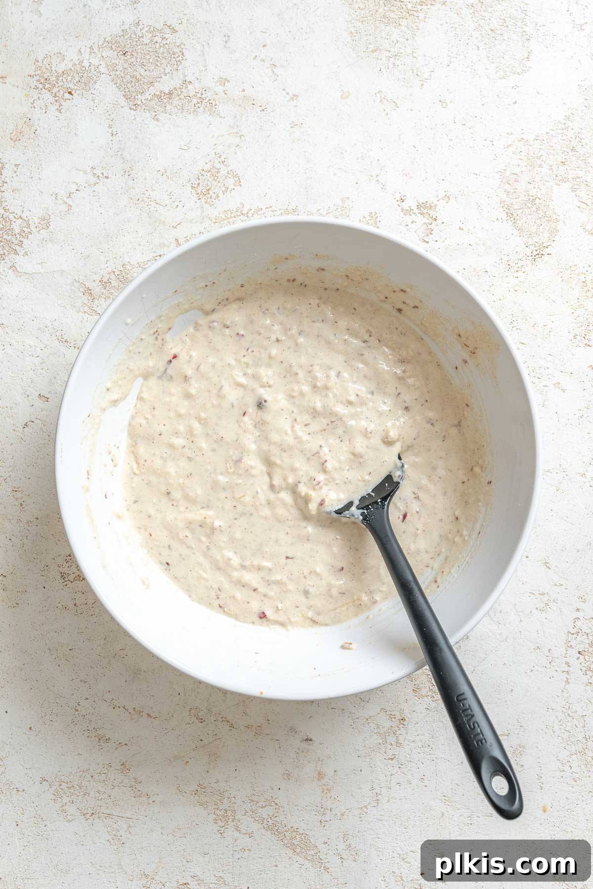 Process shot showing mixing ingredients in a bowl.