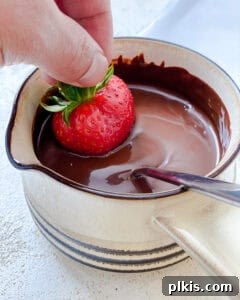 Decadent Vegan Strawberry Bites 10 process shot showing dipping strawberry in chocolate