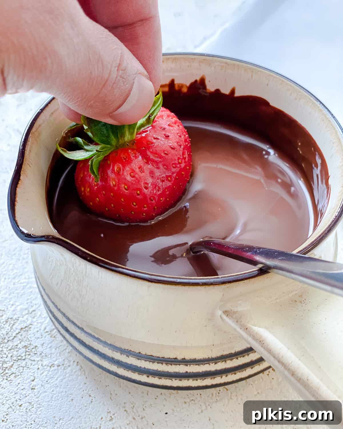 Decadent Vegan Strawberry Bites 5 process shot showing dipping strawberry in chocolate