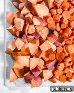 Pressure Perfect Tzimmes 6 Raw, diced yams and sliced carrots neatly arranged on a white surface