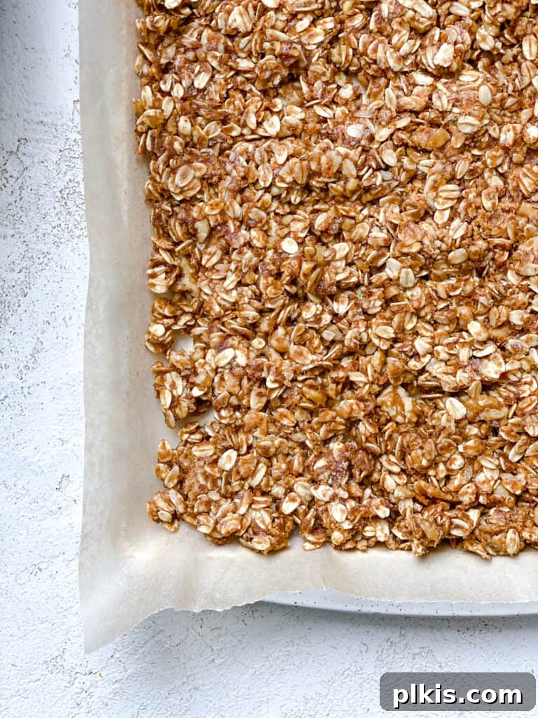 Simple Peanut Butter Granola Clusters 10 process shot of adding peanut butter mixture to baking dish