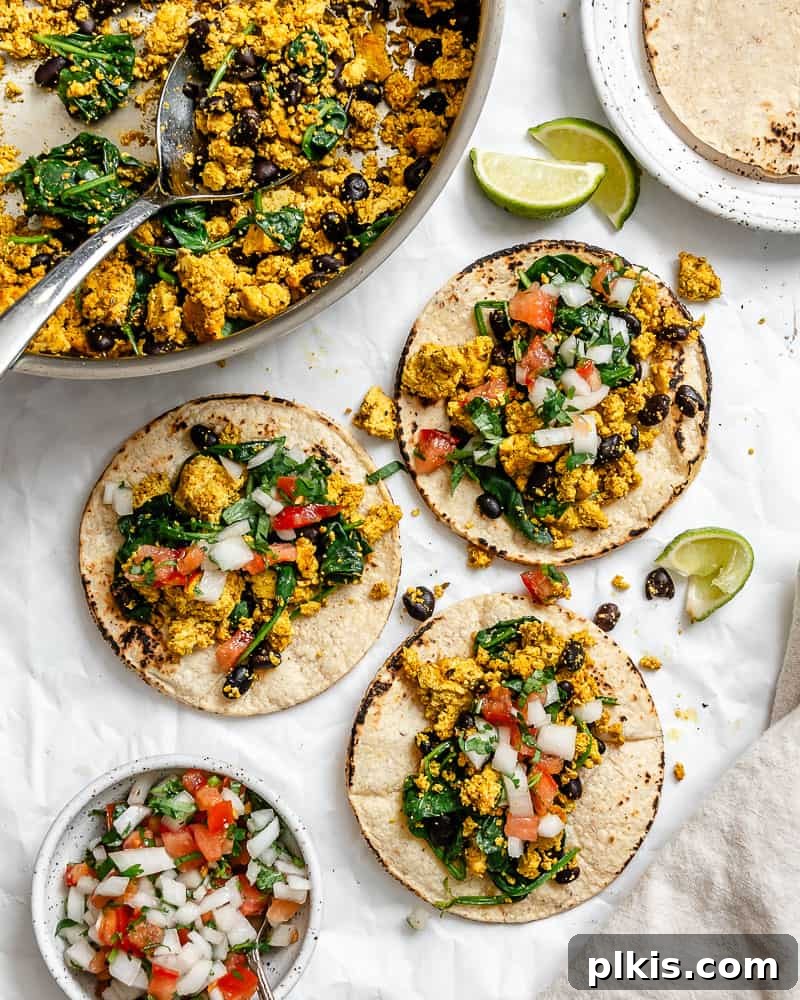 Plant-Powered Morning Tacos 2 Completed Vegan Breakfast Tacos on a white surface alongside pan of filling.