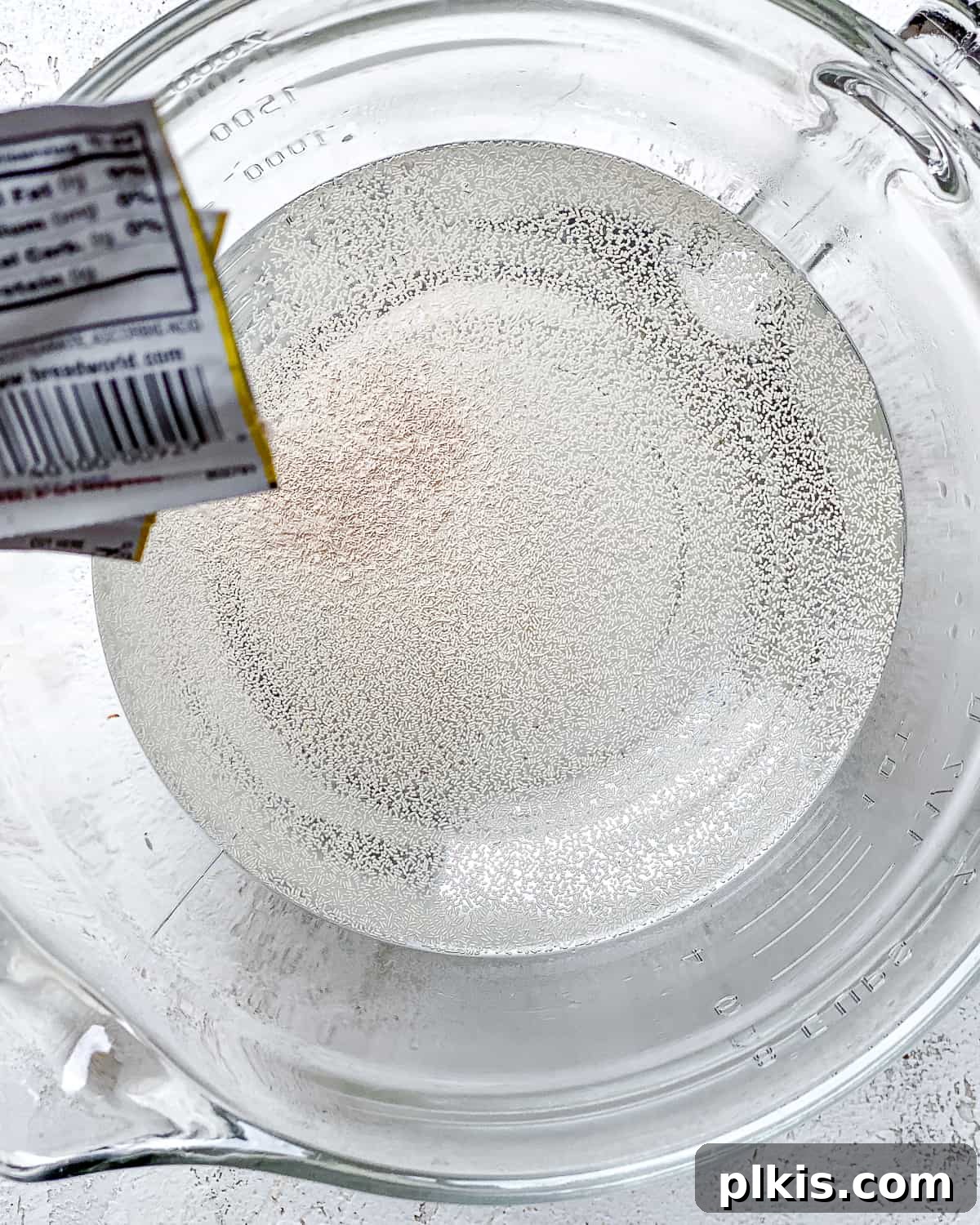 Lazy Baker's Crusty Loaf 3 process shot of adding yeast to glass bowl of water