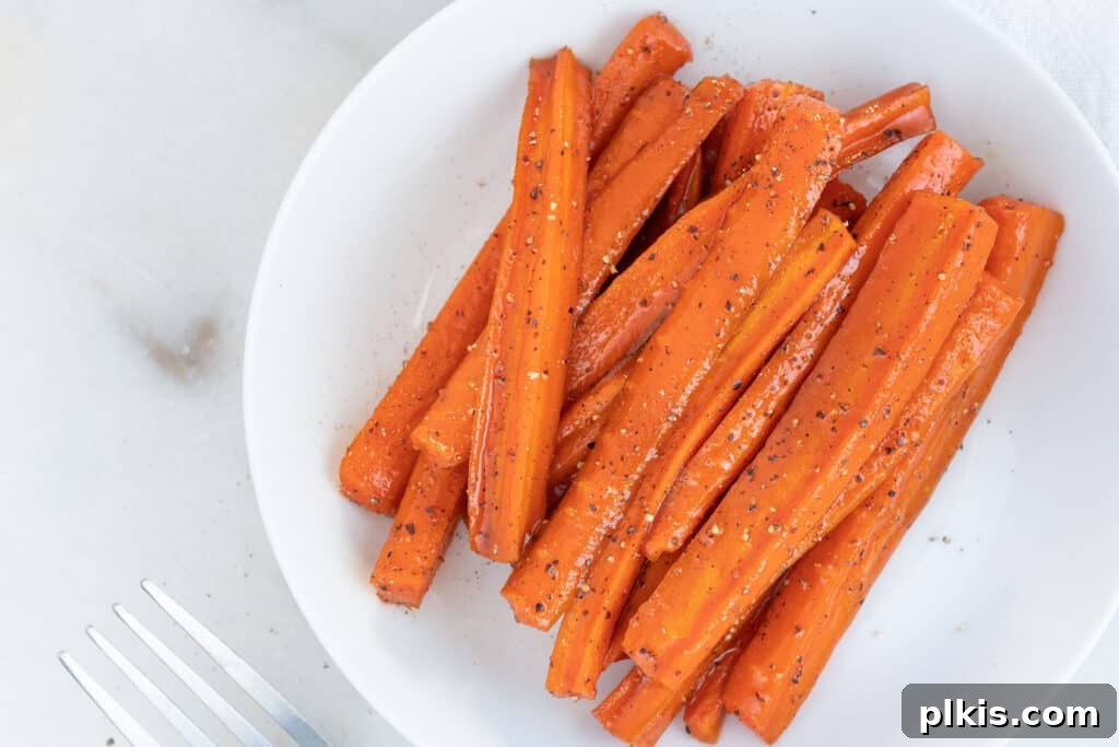 Orange Gold: The Ultimate Carrot Compendium 2 Finished cut and sliced glazed Carrots on a white plate in a white background