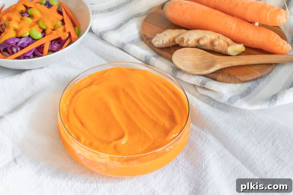 Orange Gold: The Ultimate Carrot Compendium 3 japanese carrot ginger salad dressing in a galss bowl with carrot ingredients in a white background