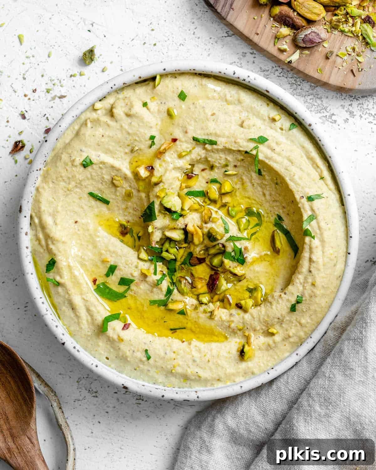 Emerald Pistachio Hummus 2 A bowl of freshly made Pistachio Hummus, garnished with chopped pistachios and a drizzle of olive oil, ready for serving.