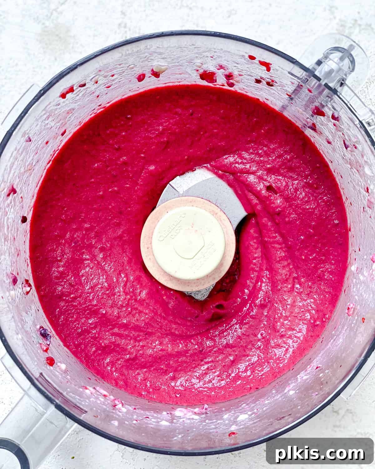 Instant Berry Tofu Nice Cream 5 Step-by-step process image showing the ingredients being blended into ice cream in a food processor.