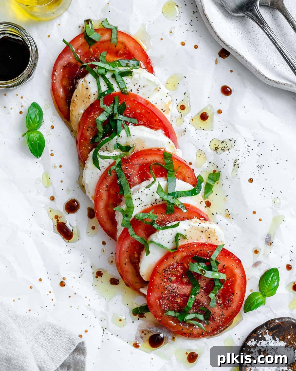 Plant-Based Caprese Delight 2 Completed Vegan Caprese Salad on a white surface, showcasing juicy tomatoes, creamy tofu, and fresh basil.