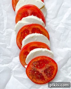 Plant-Based Caprese Delight 10 Layering tomatoes and tofu on a white surface