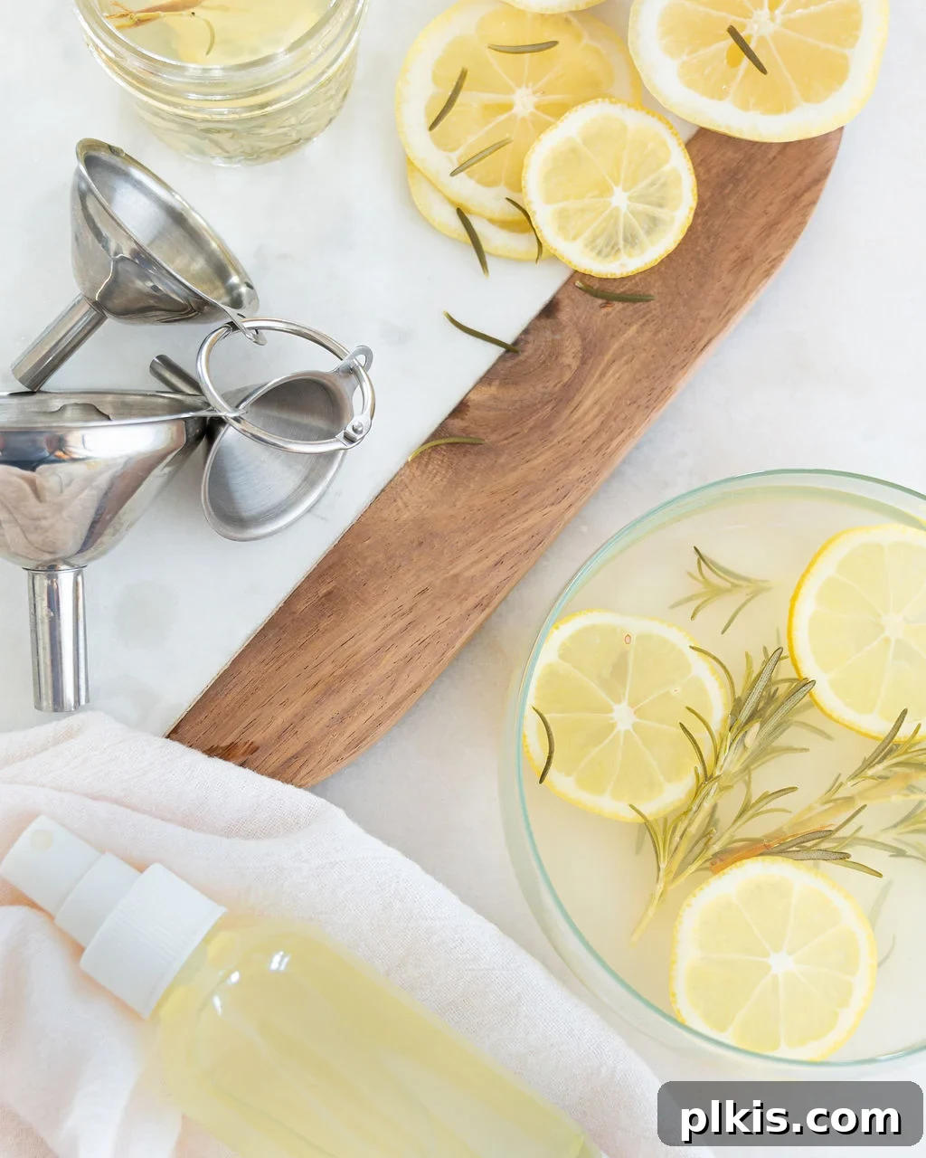 Zesty Rosemary Refresh 3 Lemon Rosemary room spray in a bottle next to sliced lemons.