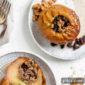 20 Delicious Vegan Autumn Desserts 13 two completed plated stuffed baked apples on white plates against a white background