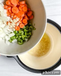 Hearty Vegan Minestrone 4 First step in cooking Vegan Minestrone Soup: adding chopped vegetables like onions, carrots, and celery to a large pot with heated oil for sautéing.