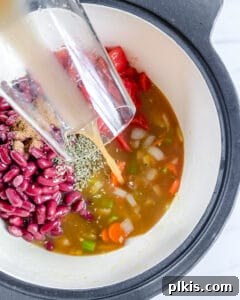 Hearty Vegan Minestrone 5 Second step in cooking Vegan Minestrone Soup: adding canned diced tomatoes, vegetable broth, and kidney beans to the sautéed vegetables in the pot.