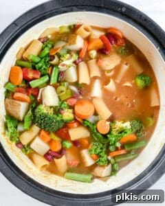 Hearty Vegan Minestrone 7 Final step in cooking Vegan Minestrone Soup: a close-up of the completed soup in the pot, seasoned and ready to be served.