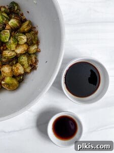 Crispy Air Fryer Brussels Sprouts 13 cooked brussels sprouts in a white bowl with wet ingredients in the background