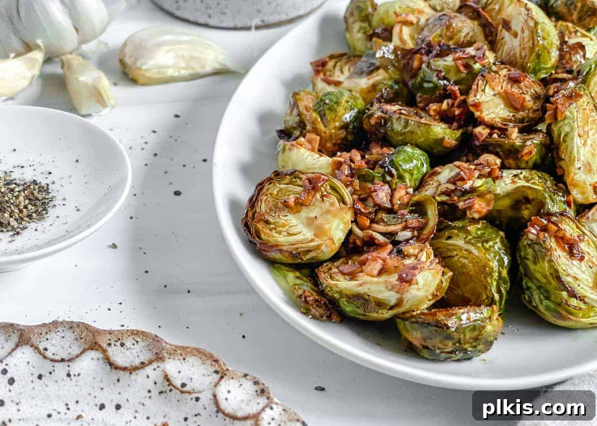 Crispy Air Fryer Brussels Sprouts 16 finished Crispy Air Fryer Brussels Sprouts plated on a white dish against a white background