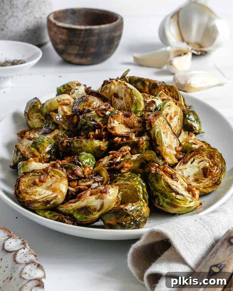 Crispy Air Fryer Brussels Sprouts 3 finished Crispy Air Fryer Brussels Sprouts plated on a white dish against a white background