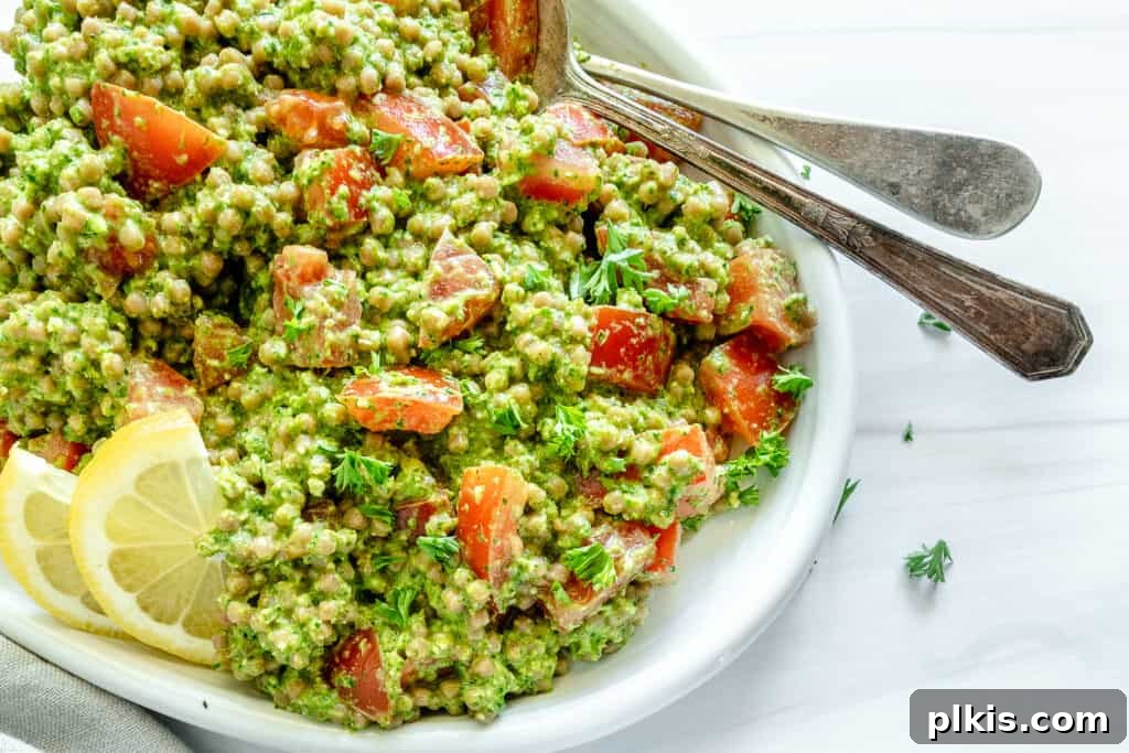 20 Effortless Plant-Based Pasta Dishes for Delicious Dinners 16 arugula pesto couscous in a white platter against a white background