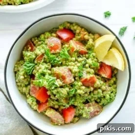 arugula pesto couscous in a white platter against a white background