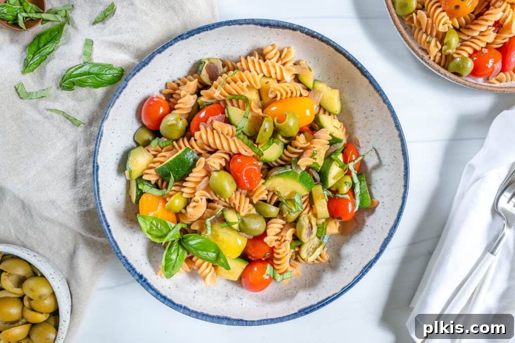 20 Effortless Plant-Based Pasta Dishes for Delicious Dinners 18 finished summertime pasta in a white plate with ingredients spread out in the background