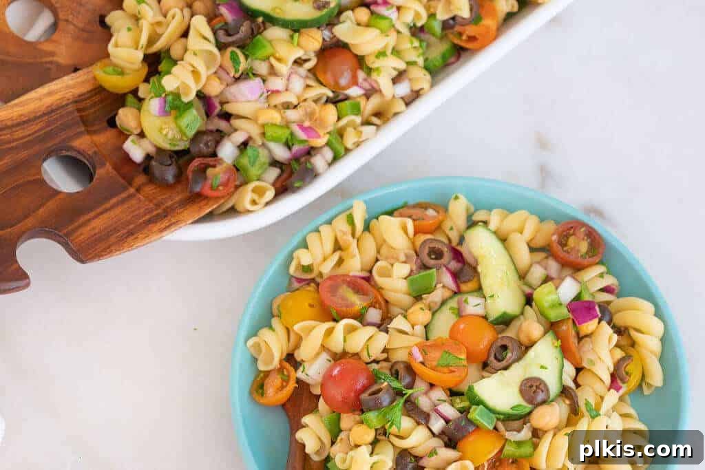 20 Effortless Plant-Based Pasta Dishes for Delicious Dinners 22 finished pasta salad in white tray and blue bowl against a white background