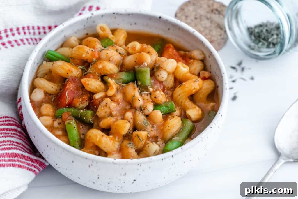 20 Effortless Plant-Based Pasta Dishes for Delicious Dinners 24 Pasta, Bean & Tomato Soup in a white bowl against a white background