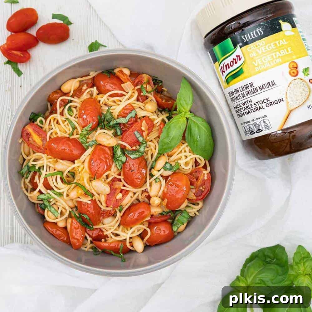 20 Effortless Plant-Based Pasta Dishes for Delicious Dinners 26 finished Tomato Basil Pasta in a gray bowl with product and ingredients against a white background