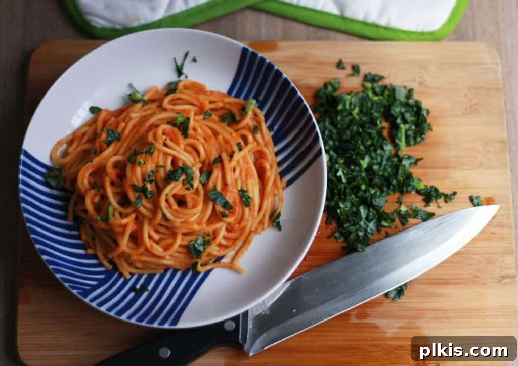 20 Effortless Plant-Based Pasta Dishes for Delicious Dinners 31 finished spaghetti on a blue and white plate with ingredients in the background on top of a wooden surface