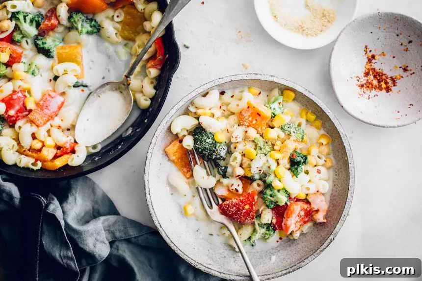 20 Effortless Plant-Based Pasta Dishes for Delicious Dinners 39 finished vegan white sauce pasta in a white dish with an iron skillet and bowls in the background
